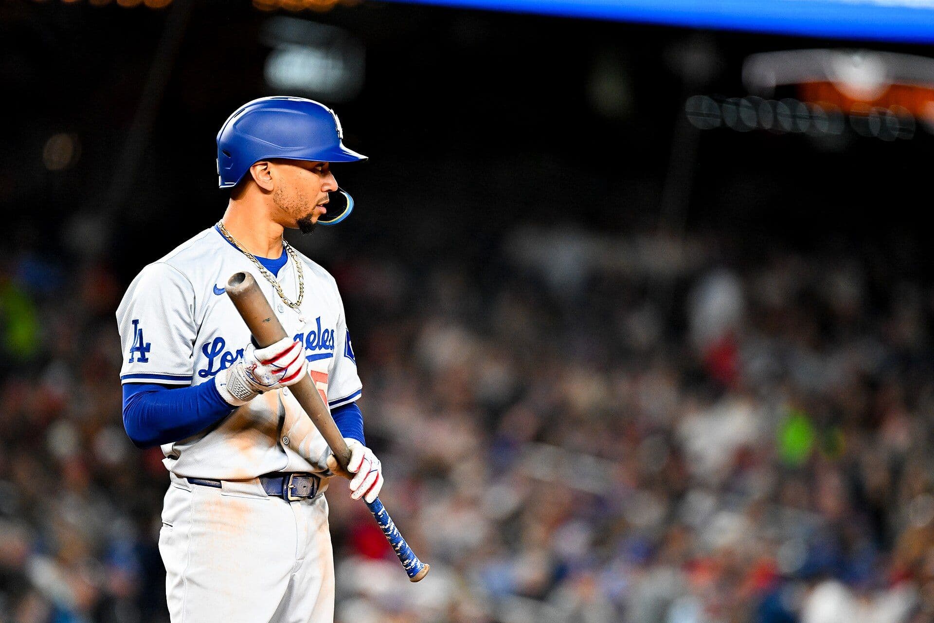 Mookie Betts of the Los Angeles Dodgers standing at the plate holding his bat, wearing a gray Los Angeles road uniform.